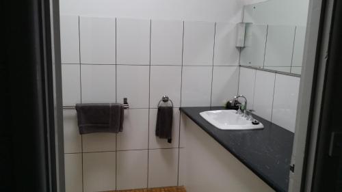 圣雷莫圣雷莫汽车旅馆的白色瓷砖浴室设有水槽和镜子