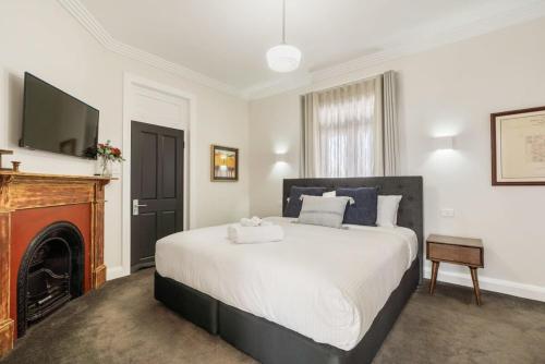 奥兰治Sanlor Suite 2 - Luxury, Comfort & Style的一间卧室配有一张带壁炉和电视的床。