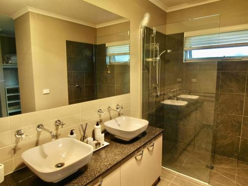 布赖特Collins Retreat - 4 Bedroom home with Pool的一间带两个盥洗盆和淋浴的浴室