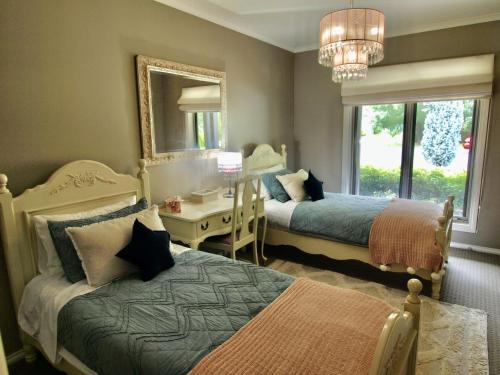 布赖特Collins Retreat - 4 Bedroom home with Pool的一间卧室配有两张床、一张桌子和一面镜子
