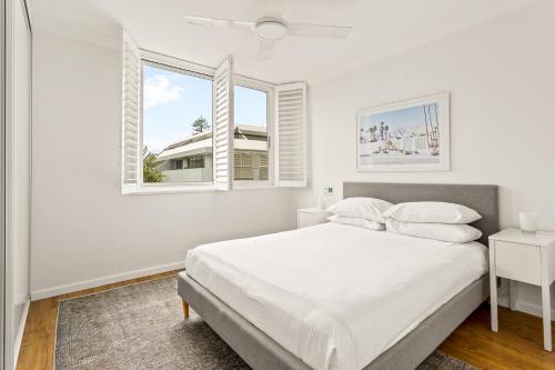 悉尼Chic apartment footsteps from Manly Beach的一间白色卧室,配有床和2个窗户