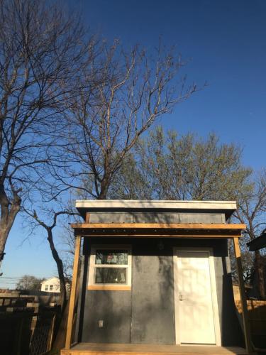 奥斯汀ATX Tiny House的树前有窗户的小建筑