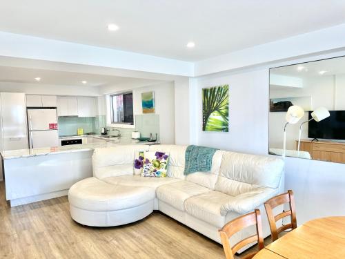 黄金海岸希拉纹假日公寓的一间带白色沙发的客厅和一间厨房