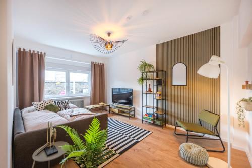 科布伦茨NEU: 100m² - ideal für Familien/Geschäftsr. - HBF的带沙发和电视的客厅