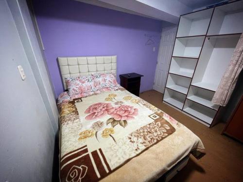 普诺Departamento Céntrico, cómodo y acogedor的一间卧室配有一张带花卉床罩的床