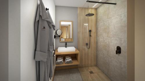 厄唐萨雷Papangue Hôtel & Spa的一间带水槽、镜子和淋浴的浴室