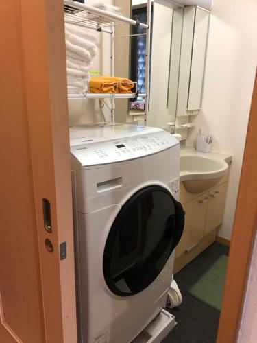 大阪SUMIDA的小型浴室内的洗衣机和烘干机