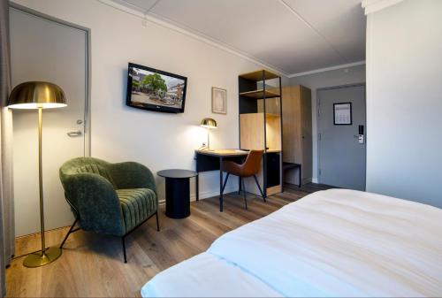 海莱乌Go Hotel Herlev的酒店客房配有一张床、一把椅子和一张书桌