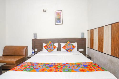 阿格拉FabHotel Prashant Palace的一间卧室配有一张带彩色毯子的床