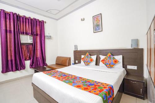 阿格拉FabHotel Prashant Palace的一间卧室配有一张床和紫色窗帘
