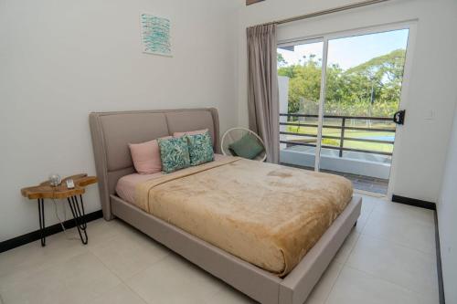 雅科Villa Paraiso do Mar的一间卧室设有一张床和一个大窗户