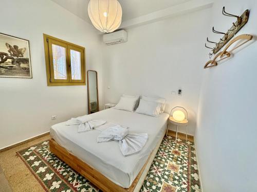 爱琴娜岛Port view apartment Aegina的一间卧室配有一张带白色床单和地毯的床。