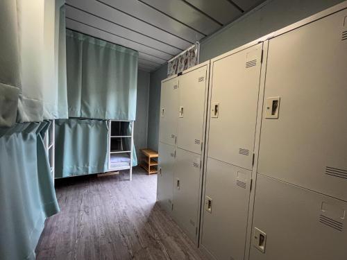 Yü-lan鉄木彩虹小屋的更衣室配有白色储物柜和蓝色窗帘