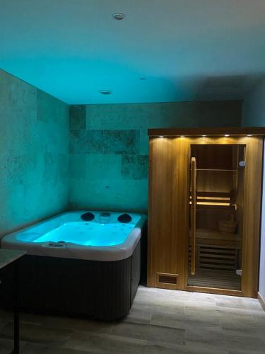 Saint-VictoretCote spa suite nord的浴室设有蓝色灯光浴缸。
