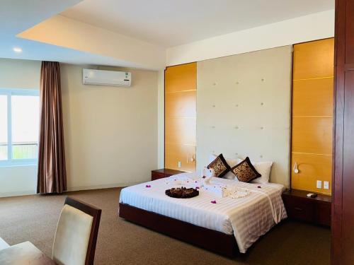 洞海Duy Tân Quảng Bình Hotel & Resort的酒店客房,配有一张带碗的床