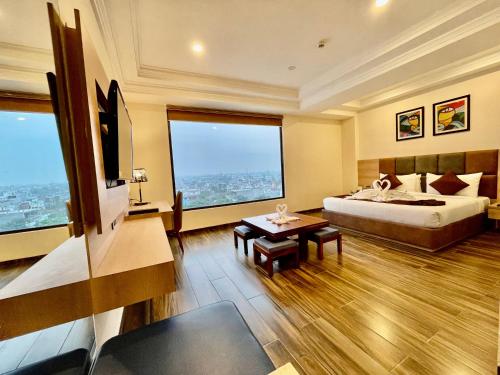 勒克瑙The Elite Lucknow Convention Hotel的酒店客房设有一张床和两个大窗户