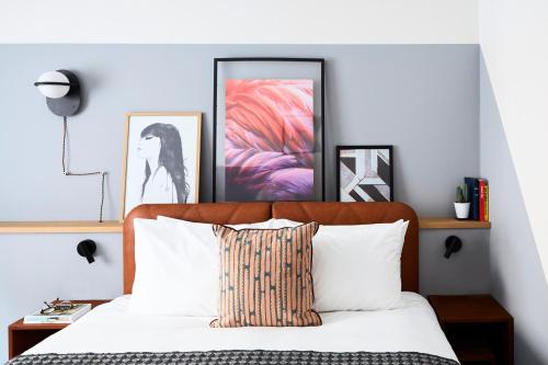 安特卫普安特卫普市中心英迪格酒店的卧室配有一张壁画和两张画的床铺。