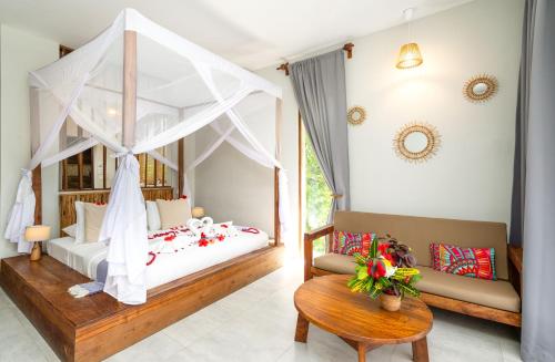 吉汶瓦Zanzibella Hotel & SPA的一间卧室配有天蓬床和沙发