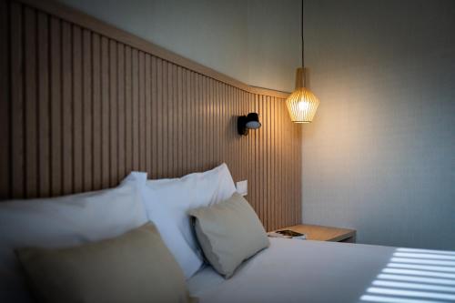 巴塞罗那MH城市公寓酒店的一间卧室配有带白色枕头和灯的床