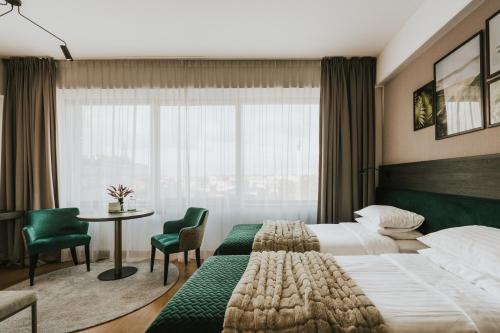 伊诺弗罗茨瓦夫Green Hotel的酒店客房,配有一张床和一张桌子及椅子