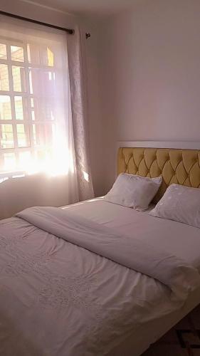 ThikaSerene Safaris Airbnb in Thika的卧室配有一张大白色床和窗户
