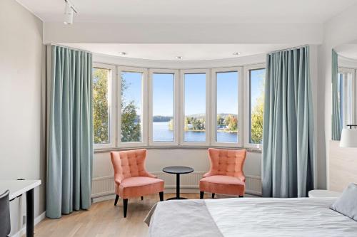 萨翁林纳索克斯胡恩科特卡原始酒店萨翁林纳的卧室配有两把椅子和一张桌子,位于窗户前