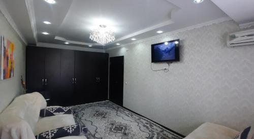 MayevkaОднокомнатная квартира, Новая!的一间墙上配有电视的房间和一张床