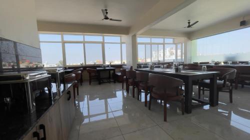 班加罗尔Hotel Banyan Tree Yeshwanthpur的餐厅设有桌椅和大窗户。