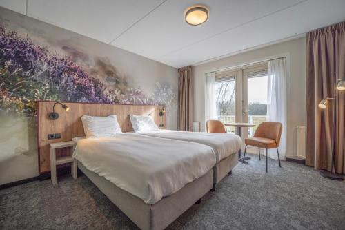 泽赫瑟弗莱彻酒店的酒店客房设有一张大床和一张桌子。