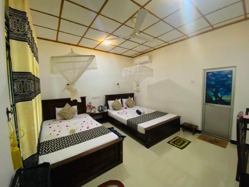 锡吉里亚Lucky Villa Sigiriya的一间客房内配有两张床的房间