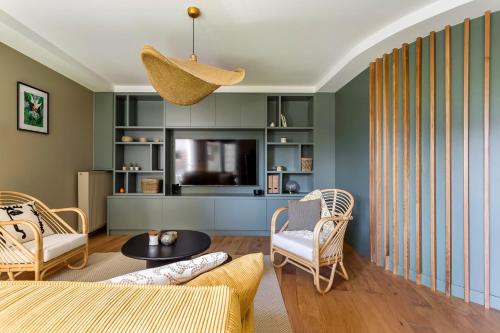 里昂Appartement spacieux avec balcon 6pers的客厅配有沙发、椅子和电视