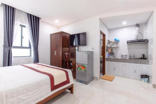岘港Bao Ngoc Hotel & Apt的一间带一张床和一台冰箱的卧室和一间厨房