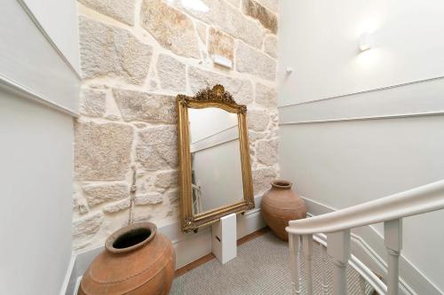 波尔图Palácio Fenizia Lux Apartments的走廊上设有石墙和镜子