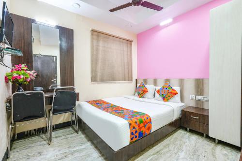 钦奈FabExpress Raj Supreme Residency的卧室配有一张床、一张桌子和椅子