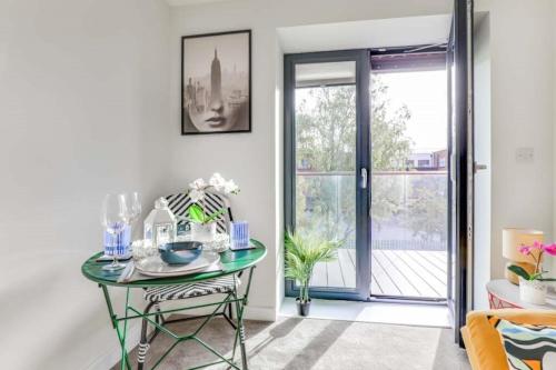 卢顿Luton Cozy & Lovely Stay for Contractors的一间设有玻璃桌和玻璃门的房间