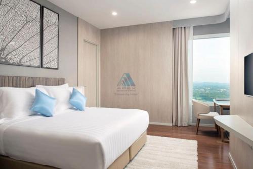 纳仲天ไวท์ แซนด์ บีช เรสซิเดนซ์ พัทยา(White Sand Beach Residences Pattaya)的一间卧室配有一张带蓝色枕头的大床