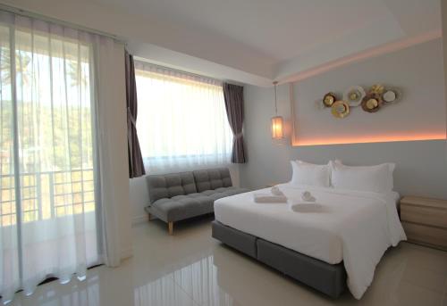 卡马拉海滩Kamala Havana的卧室配有一张白色的大床和一张沙发。