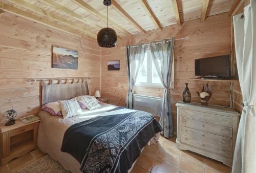 圣吉隆Maisonnette à la campagne Ariège的一间卧室配有一张床、一台电视和一个梳妆台