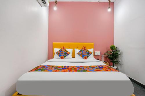 苏拉特FabHotel Sky City的一间卧室配有一张带黄色床头板的大床