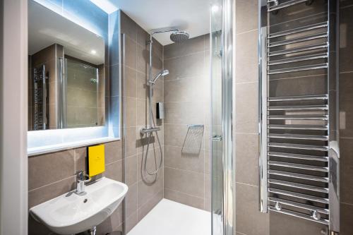 都柏林Staycity Aparthotels Dublin City Centre的带淋浴、盥洗盆和镜子的浴室