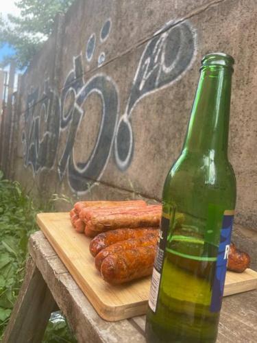 特木科Casa 2 habitaciones en Labranza - Temuco的桌子上放着一瓶啤酒和一些香肠