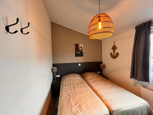 博文卡尔斯佩尔Exclusieve vakantievilla ***** Markermeer的一间卧室配有一张床和一个吊灯