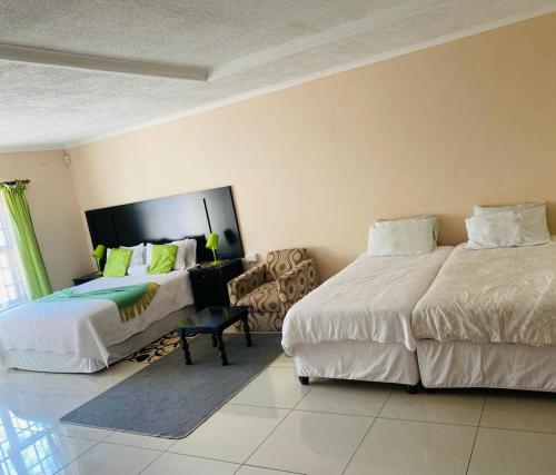 哈博罗内Phase 4: 5 Bed luxury Villa的一间卧室配有两张床和椅子