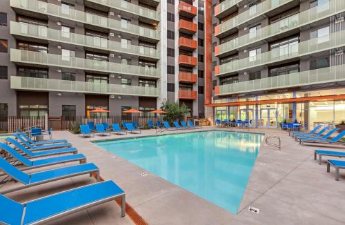 凤凰城Sophisticated City Living Apartments at Roosevelt Point, Phoenix的一座带蓝色躺椅的游泳池和一座建筑