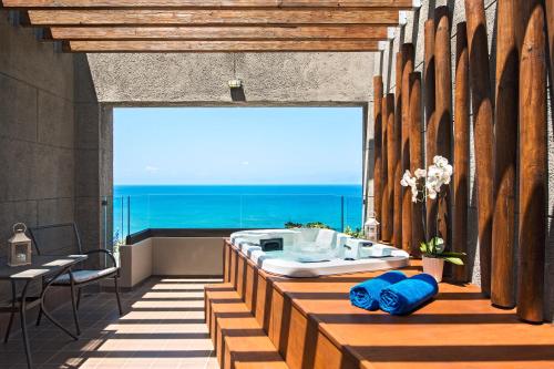 依克希亚舍拉顿罗德斯度假酒店的带浴缸的浴室,享有海景。