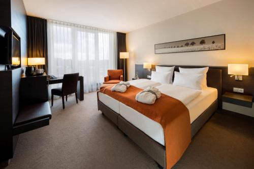 吕贝克吕贝克阿特兰蒂克酒店的酒店客房设有一张大床和一张书桌。