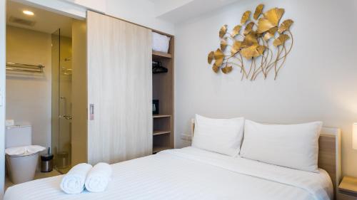 普吉镇Уютные апартаменты в Laguna Skypark的一间卧室配有一张带两条白色毛巾的床