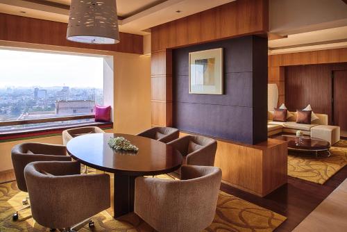 钦奈钦奈凯悦王朝酒店的客厅配有桌椅和沙发