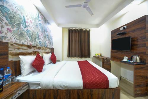 新德里Grand Empire Suites By Delhi Airport的一间卧室配有一张大床和电视