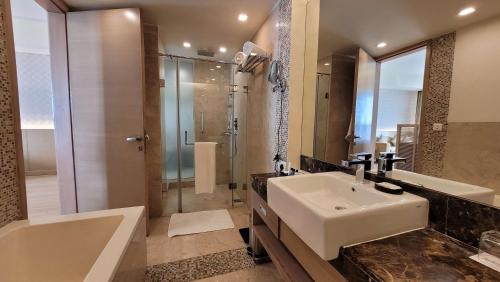 大诺伊达大诺伊达区丽笙酒店的浴室配有水槽、淋浴和浴缸。